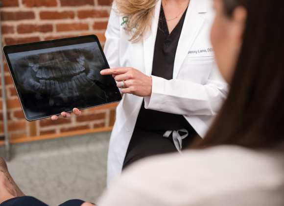 An oral surgeon showing a close up of a wisdom teeth x-ray to patient.